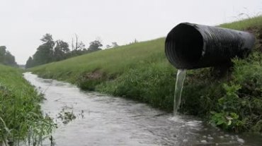 城市建设美丽郊外河溪草地下水管排放水水流运动视频素材