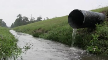城市建设美丽郊外河溪草地下水管排放水水流运动视频素材