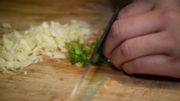 厨师切蒜头成蒜粒葱为葱花熟手快速巧手切开视频素材