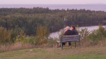 恩爱夫妻在山上椅子享受湖边自然风光镜头视频素材