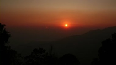 山峦间日出太阳从云层里露出视频素材