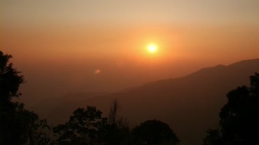 山峦间日出太阳从云层里露出视频素材