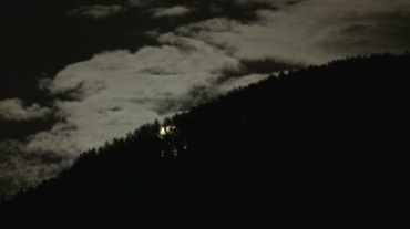 月亮从树林后慢慢升起空中云彩移动视频素材