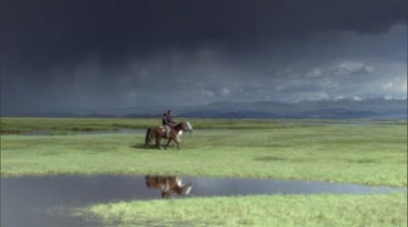 牧民在草原上骑马路过河流视频素材