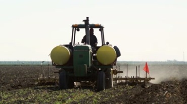拖拉机在农田里翻地耕地和犁地视频素材