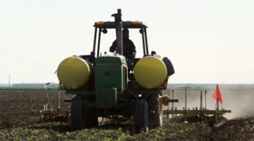 拖拉机在农田里翻地耕地和犁地视频素材