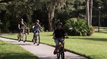 外国小孩在公园里骑自行车单车视频素材