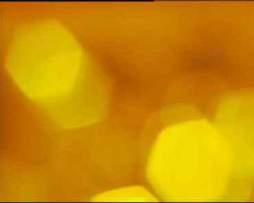 黄色朦胧模糊六角光斑亮斑镜头动态背景视频素材