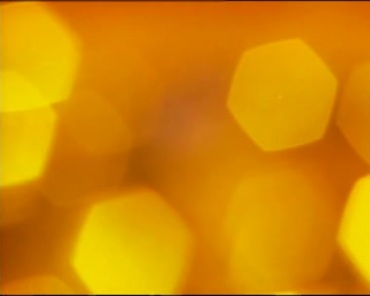 黄色朦胧模糊六角光斑亮斑镜头动态背景视频素材
