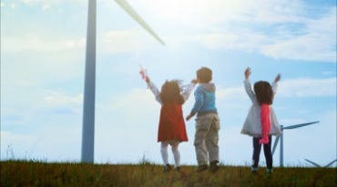 孩童在草原风电风车前欢呼跳跃幸福快乐时光视频素材