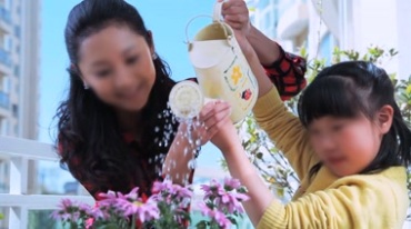 小女孩和妈妈给喷壶加水浇花视频素材
