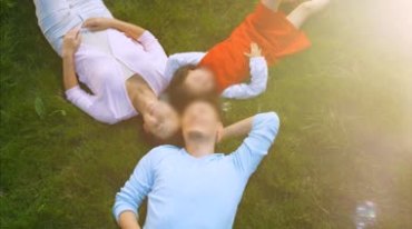 一家三口头靠头躺在草坪上视频素材