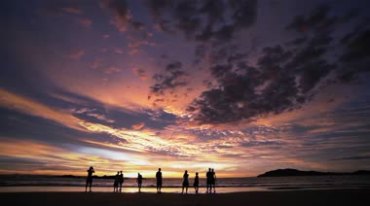 夕阳下彩霞海滩海岸人物影子剪影实拍视频素材