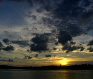 夕阳的天空一朵朵太阳光折射的黑云飘过视频素材